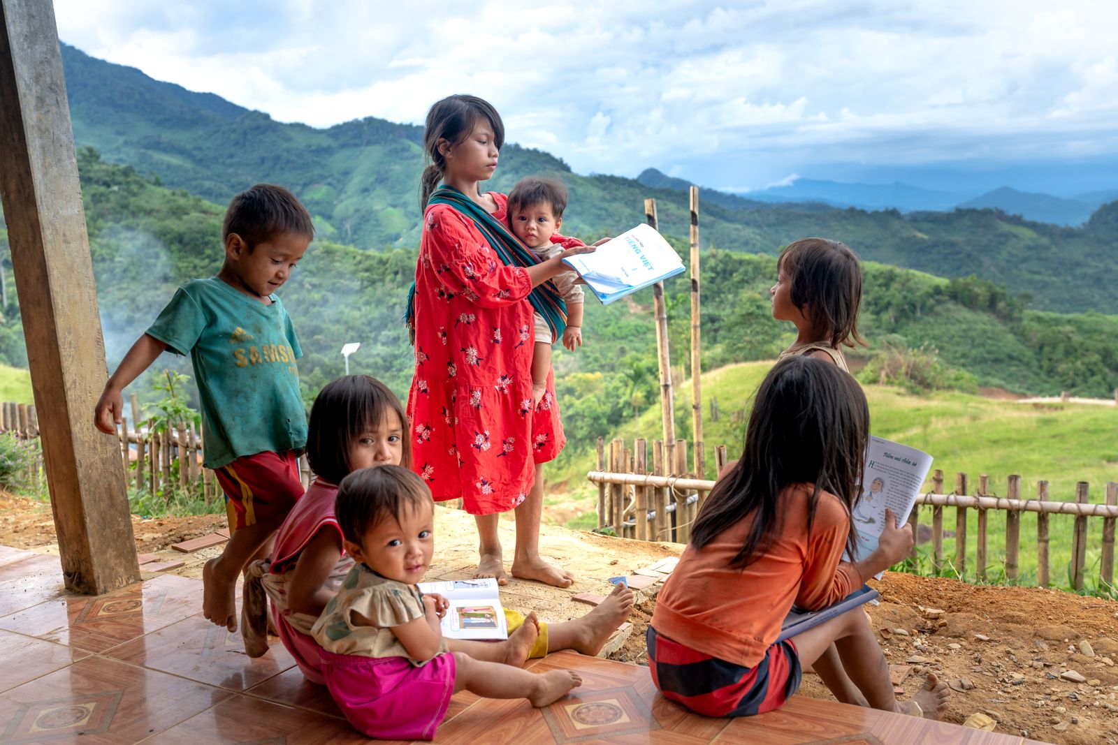 Children reading together outdoors in a mountain village
